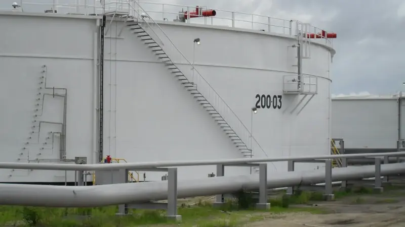 Refurbished crude oil storage tank with newly coated shell and associated pipework at a tank farm