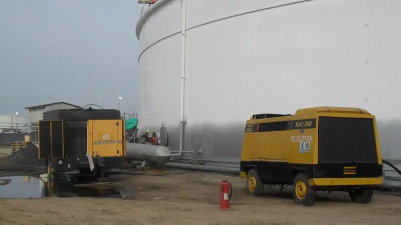 Bank of diesel air compressors positioned beside a tank farm for blasting works